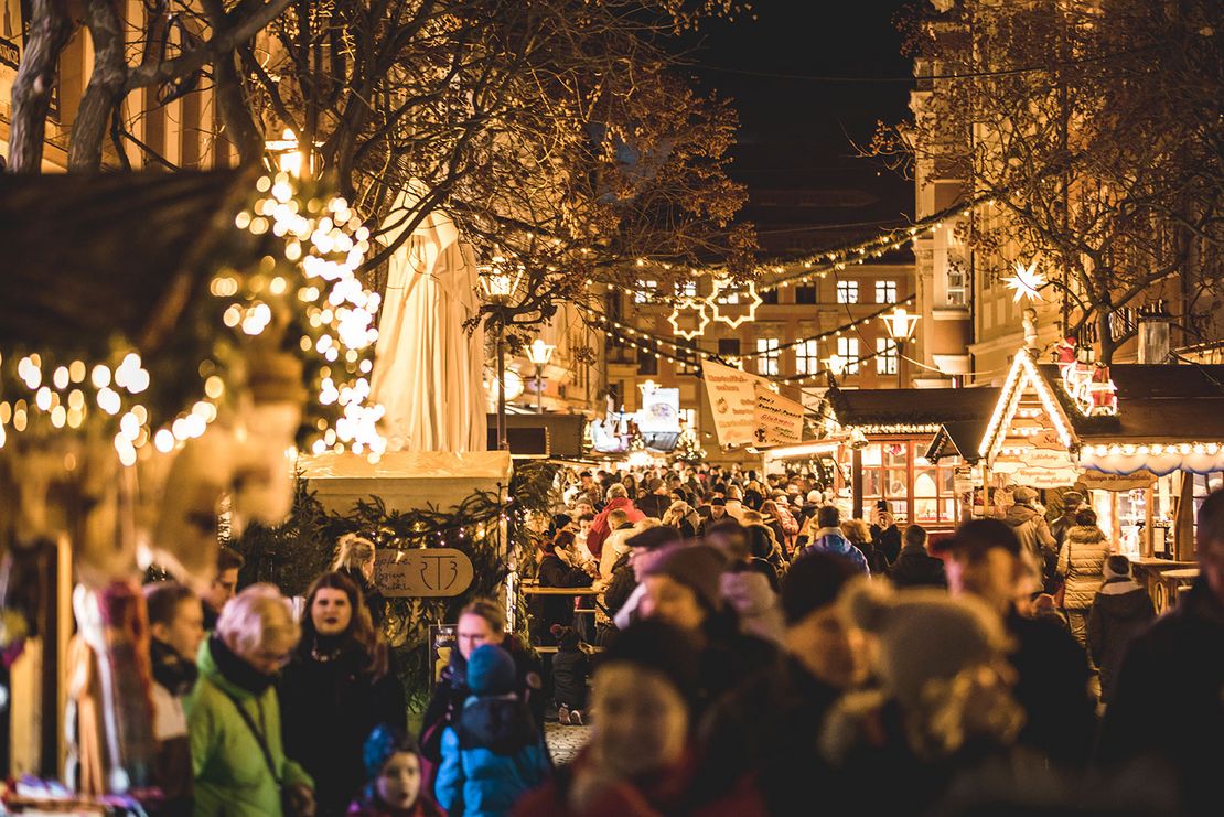 Viele Menschen halten sich an den einzelnen Weihnachtsmarktständen die auf der Reichenstraße entlang stehen auf.